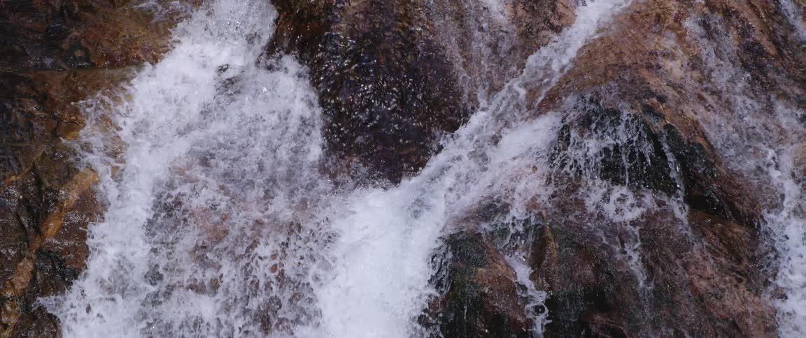 A wide waterfall rushes down the side of a canyon