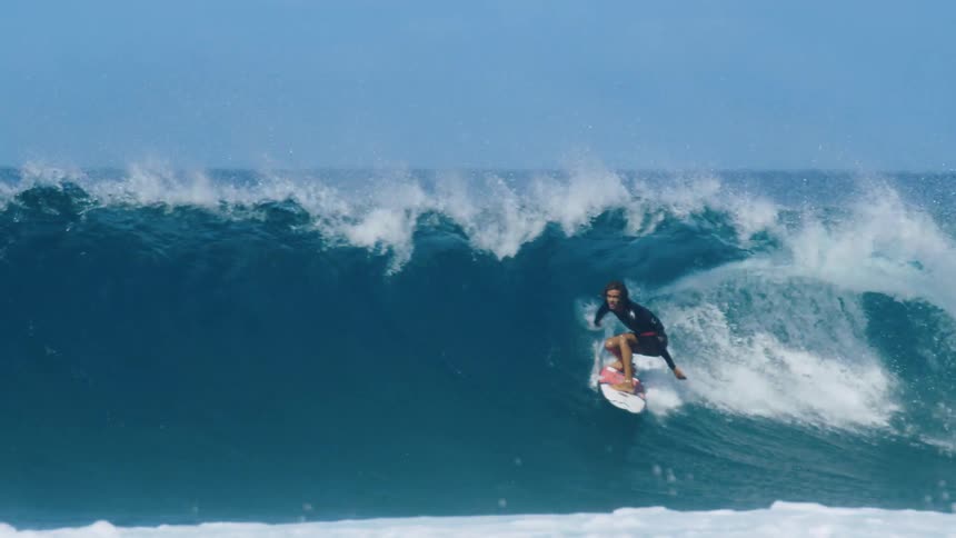 A young man surfs on large waves in the ocean