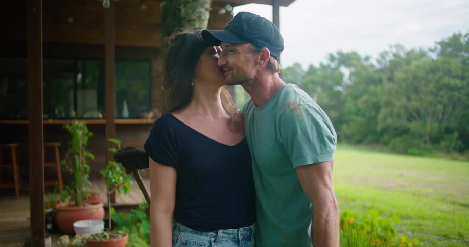 A man kisses his wife and shows her the yard