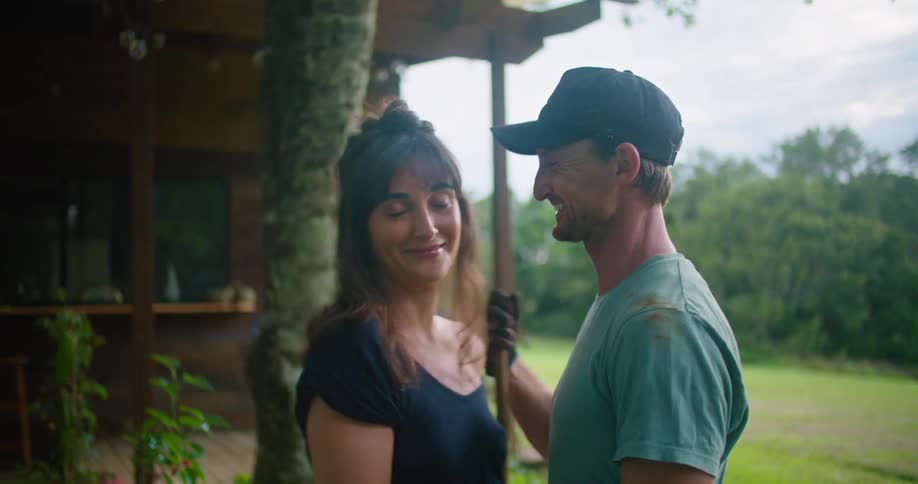 A man hugs his wife while they work in their yard