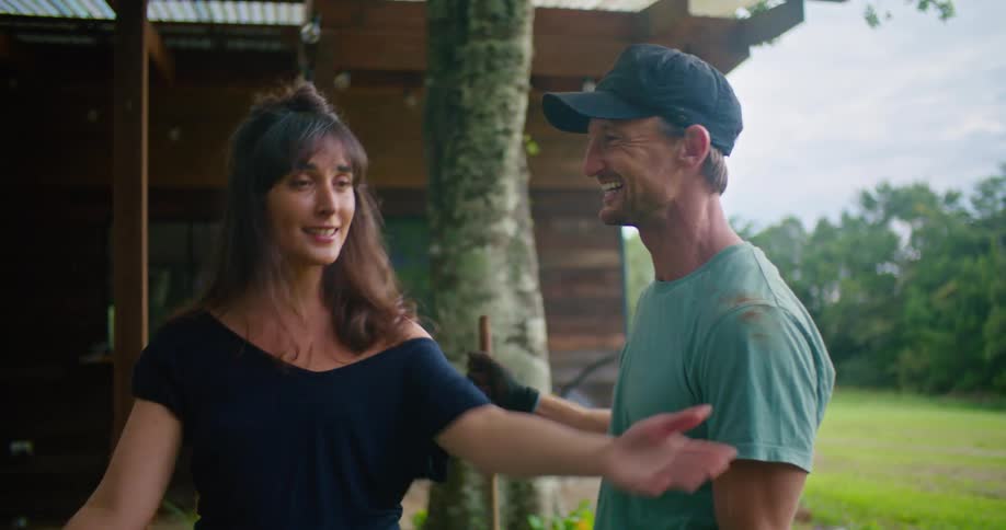 Young happy couple working in the backyard talking and kissing each other