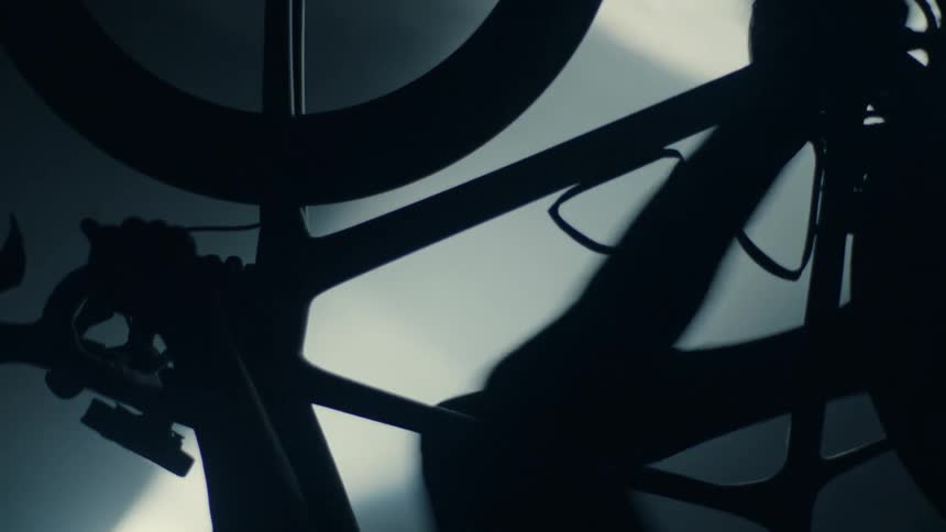 A person is riding a stationary bike in the dark
