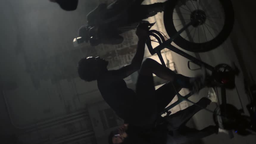 People take pictures of a man as he cycles on a stationary bike