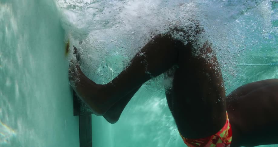 A person is swimming underwater in a pool