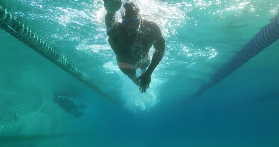 A man is swimming in a pool during the day