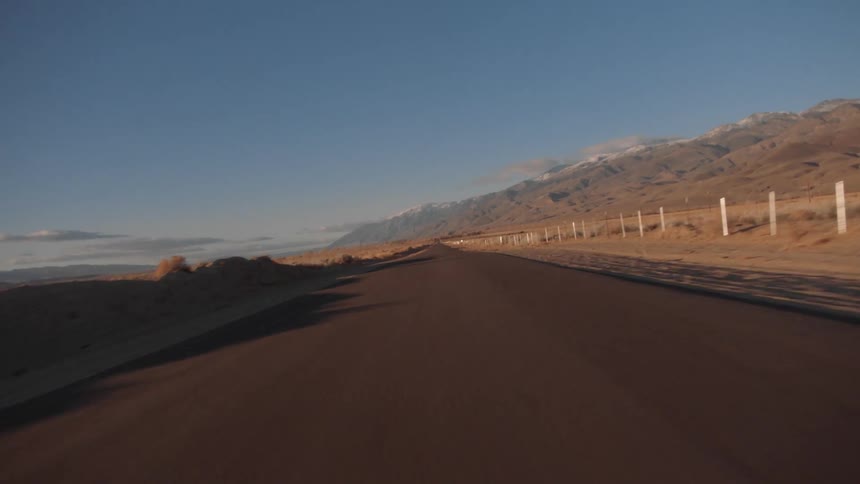 A rural road with hills in the distance at dawn