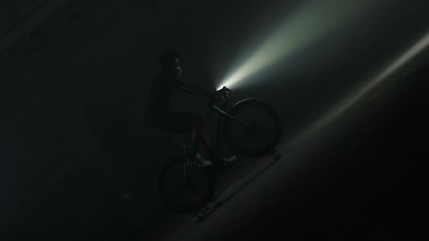 A person is riding their bike in a dark room