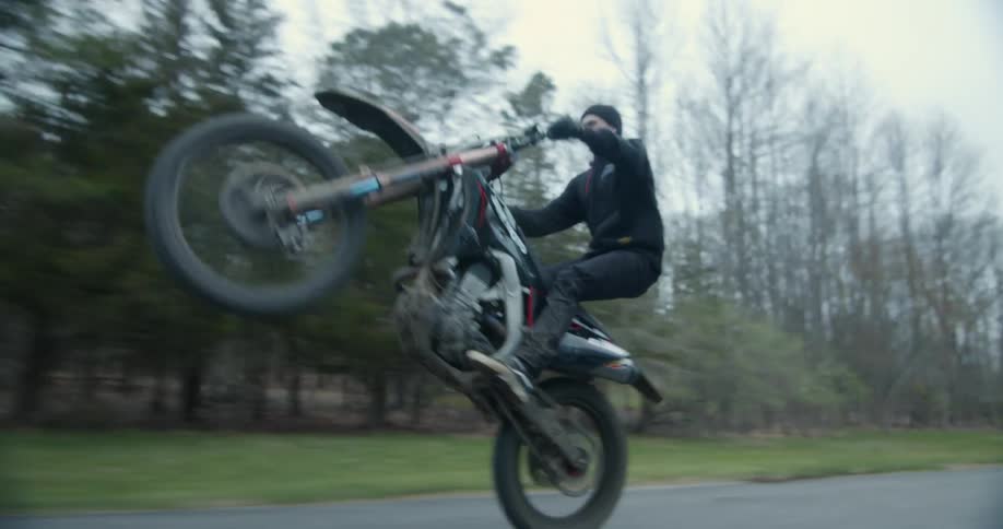 A man is doing stunts on his motorcyle in spring
