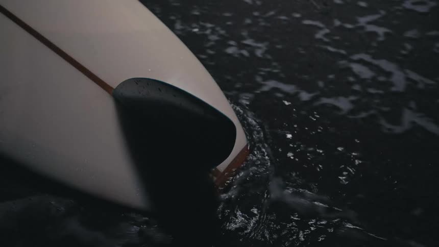 Waves rolling over a surfboard on the shore