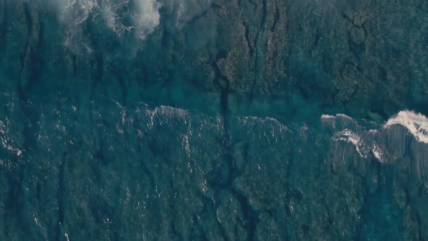 Birds eye view of waves crashing in the ocean