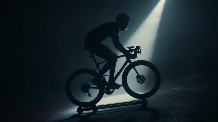 A person is exercising on a workout bike indoors