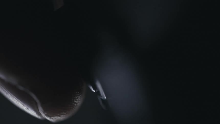 Close up of a finger pressing the shutter button on a camera triggering a flash