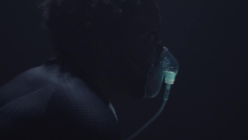 Bright lights flash as a man with a breathing mask on looks up