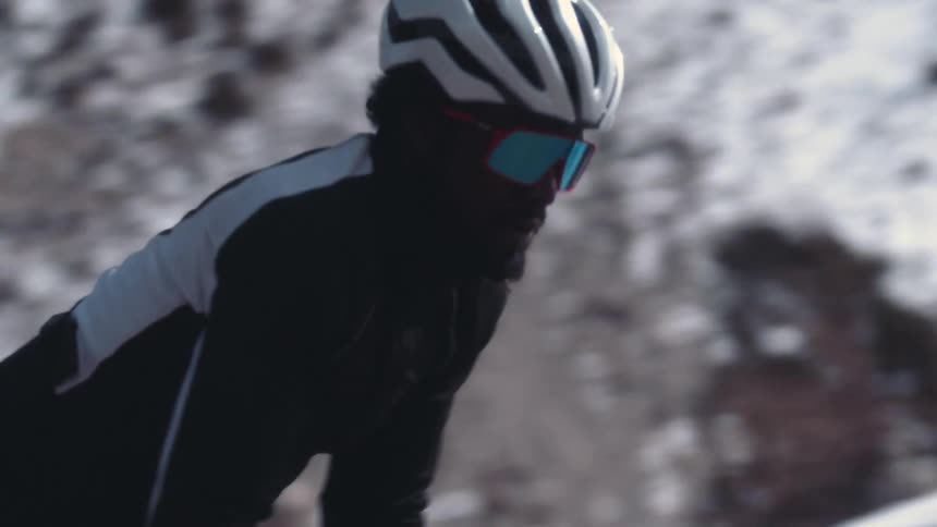 Two men are bicycling together outdoors in winter