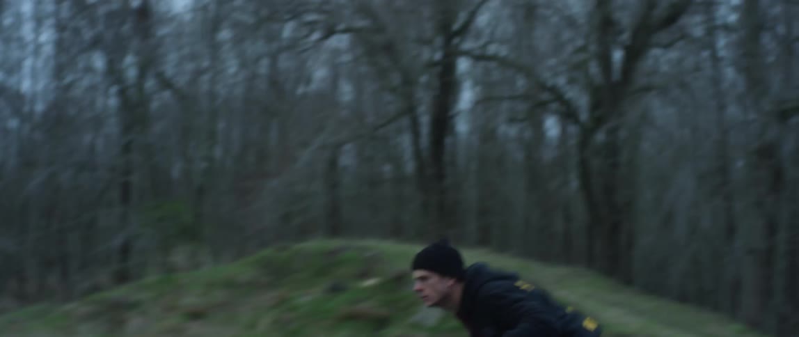 A man is riding a motorcycle and doing stunts in a forest
