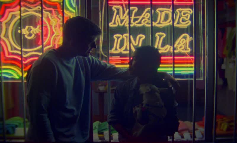 A couple kiss in front of the store at night