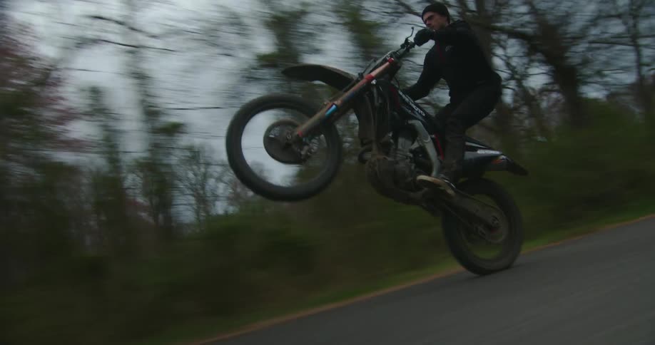 Person riding dirt bike and doing stunts