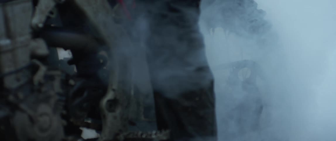 A person sits on a dirt bike as smoke fills the air