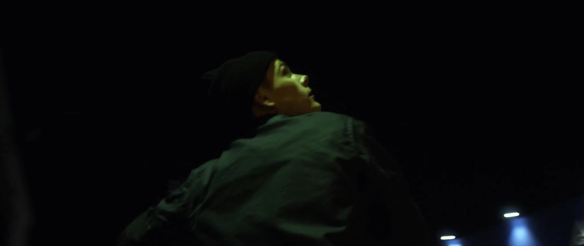 A man looking around while parked on a motorcycle at night