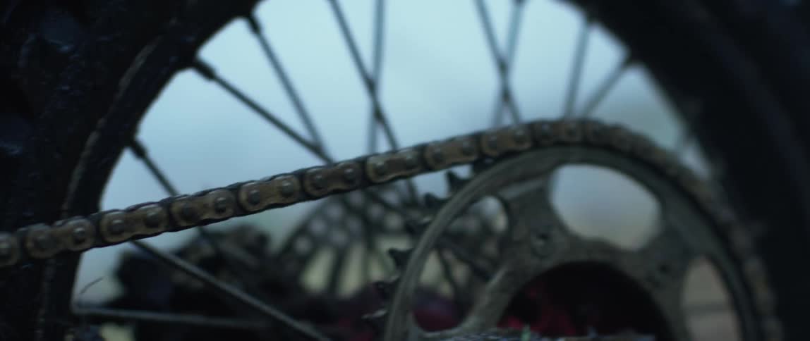 The tire and chain of a motor bike rocking back and forth