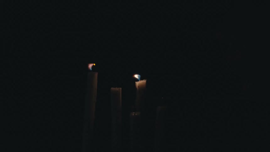 Five candles are burning in the darkness and someone blows them out