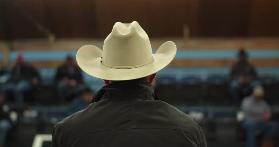 A man in a cowboy hat talking to a crowd