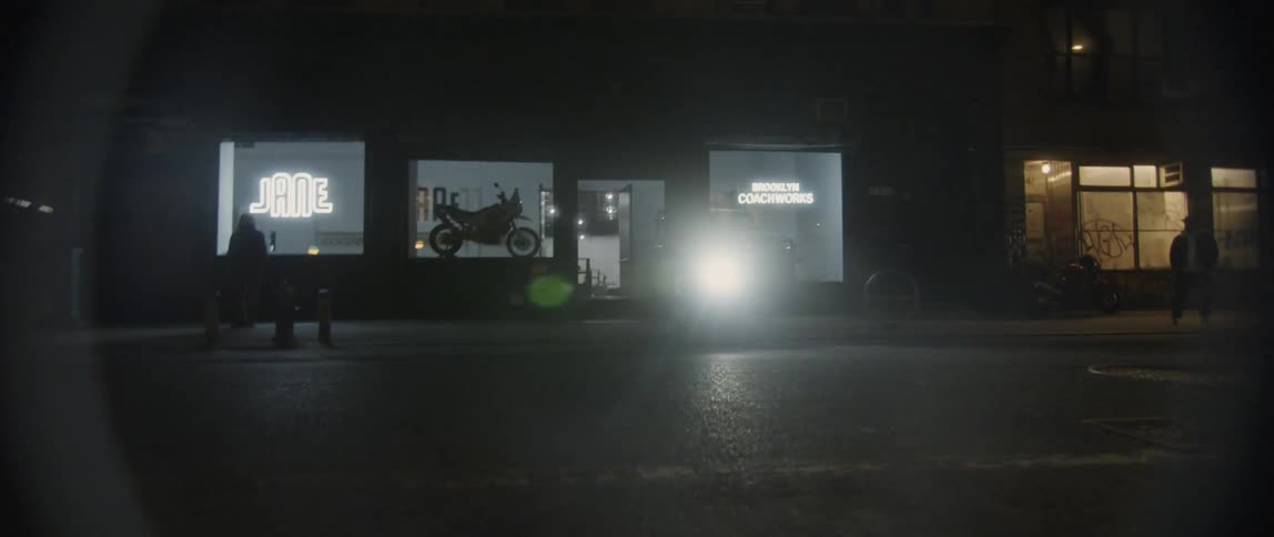 A man speeds off on his motorcycle while leaving a motorcycle shop