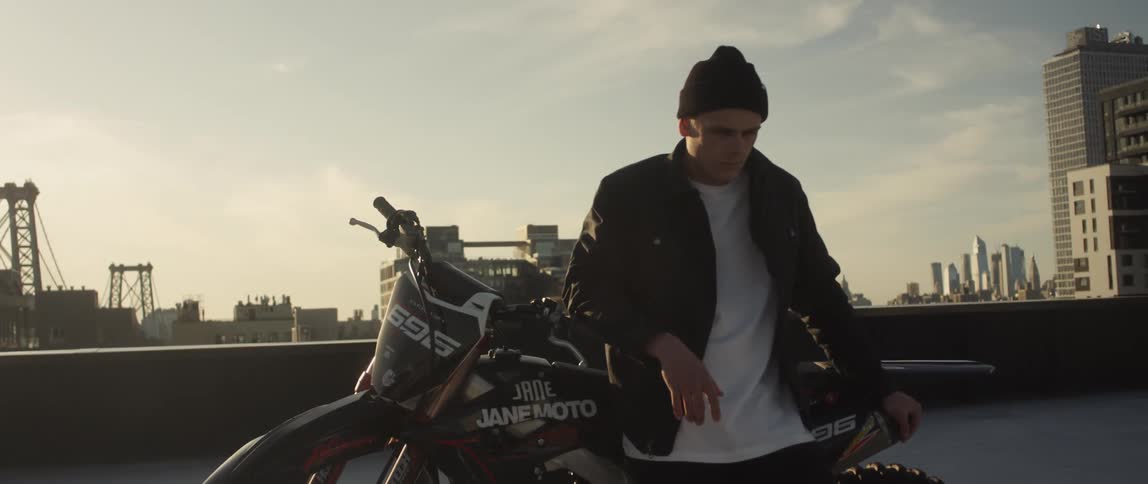 A man leans against his motorcycle on the roof