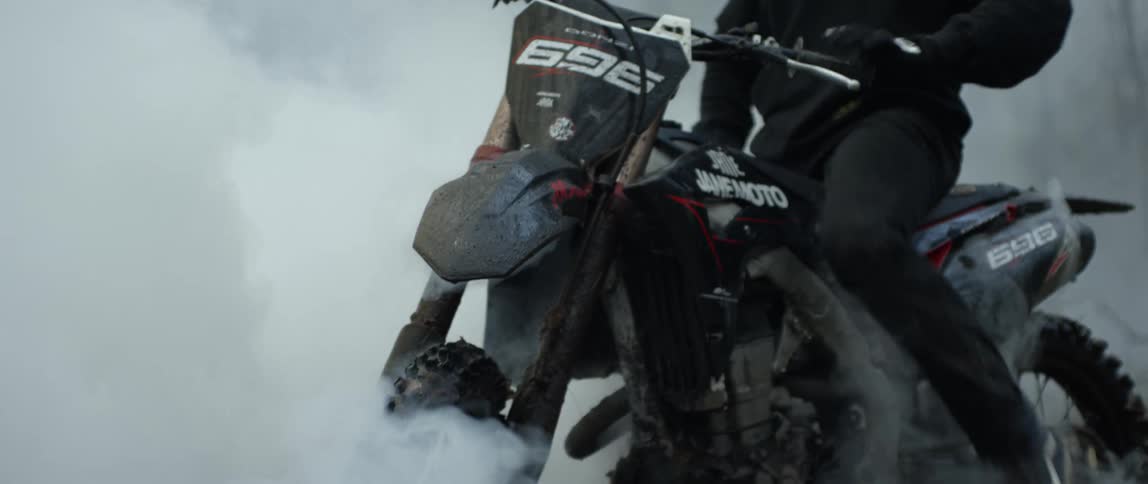 Fog swirling around a person on a dirt bike in a forest