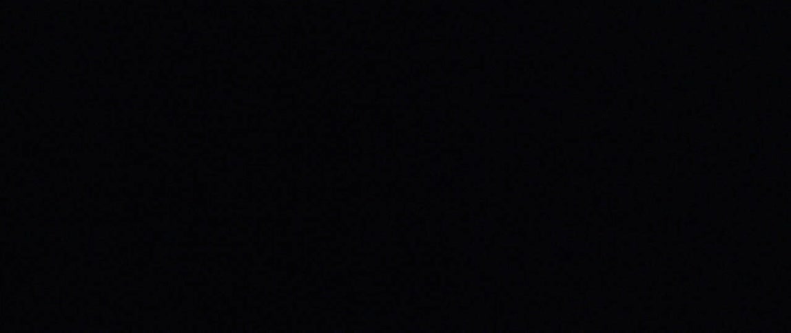 A light flashes on and off as focus zooms in on the logo on a persons shirt