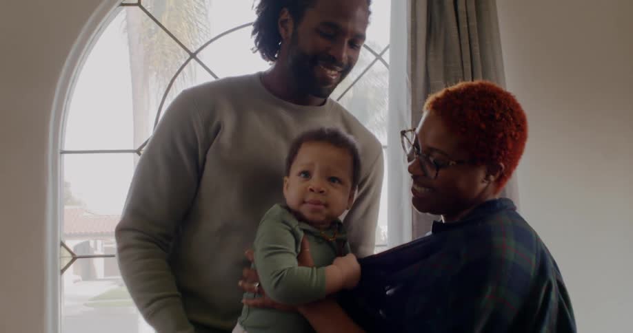 A mother and son hold their son in the room
