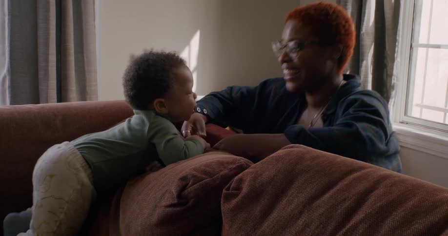 Mother and her baby child playing and bonding on the couch in the living room