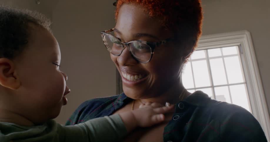 A mother laughs as she holds her son