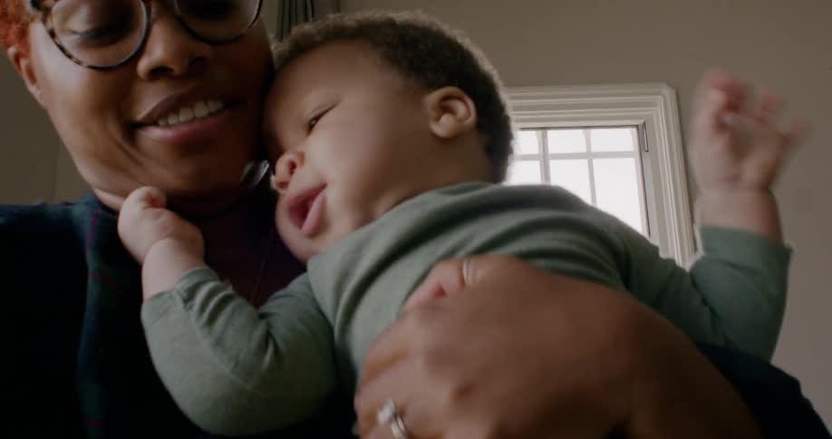A boy moves around in the womans arms