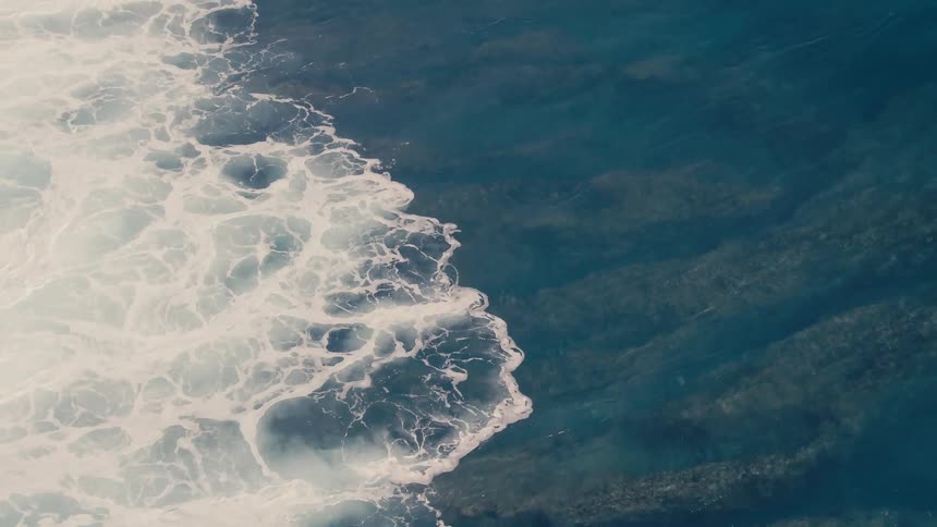 Aerial view of waves moving across the surface of the sea