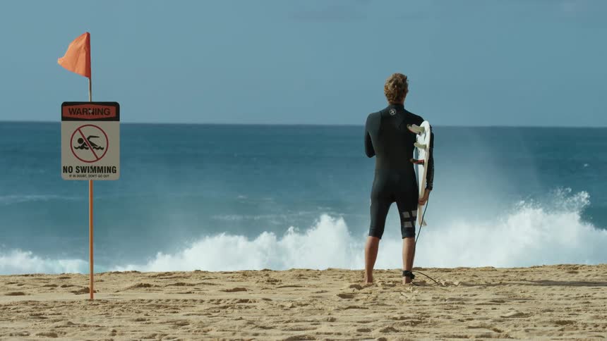 A man standing outdoors on the beach