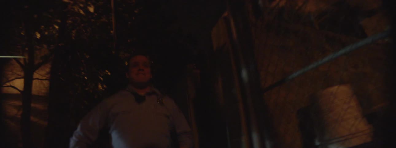 A man is running quickly down an alley at night