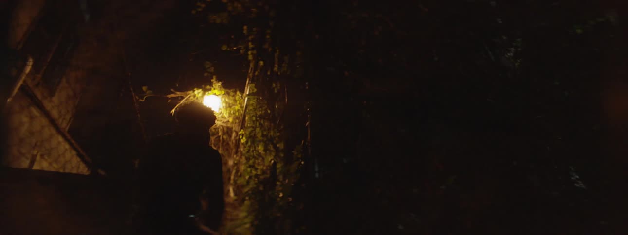 A man runs down a dark alleyway