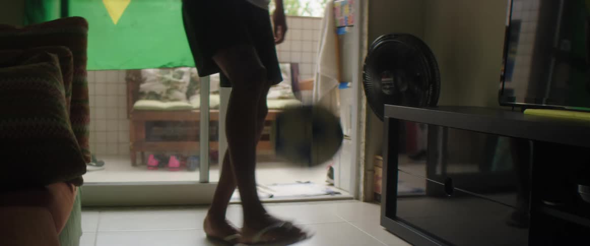 A young man dribbles a soccer ball while standing in his home
