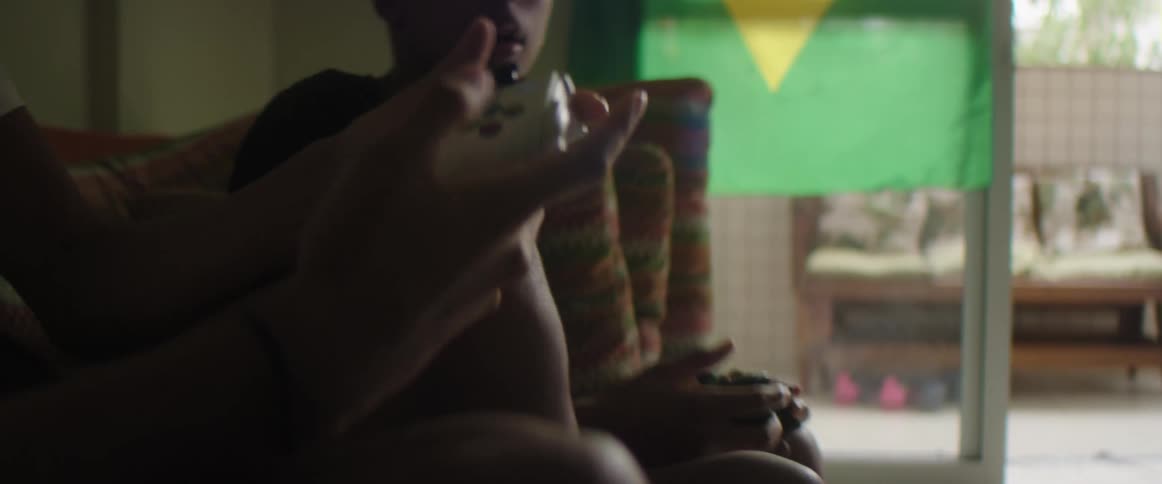 Youths sitting on sofa play with game with game controller