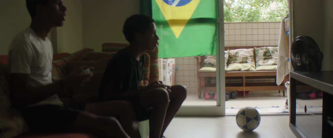 Friends sitting on the living room playing video games at home