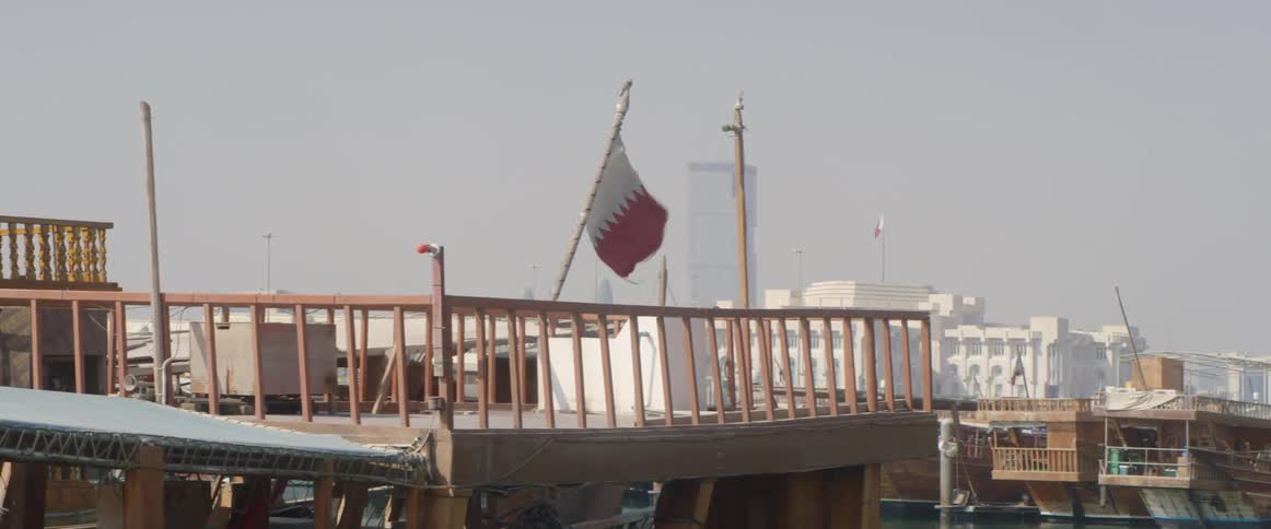 A flag files in the wind on a pier overlooking the sea