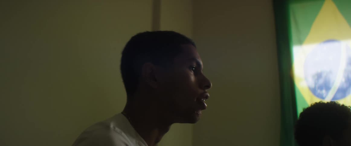 A young man and a boy play video games together in a living room during the day