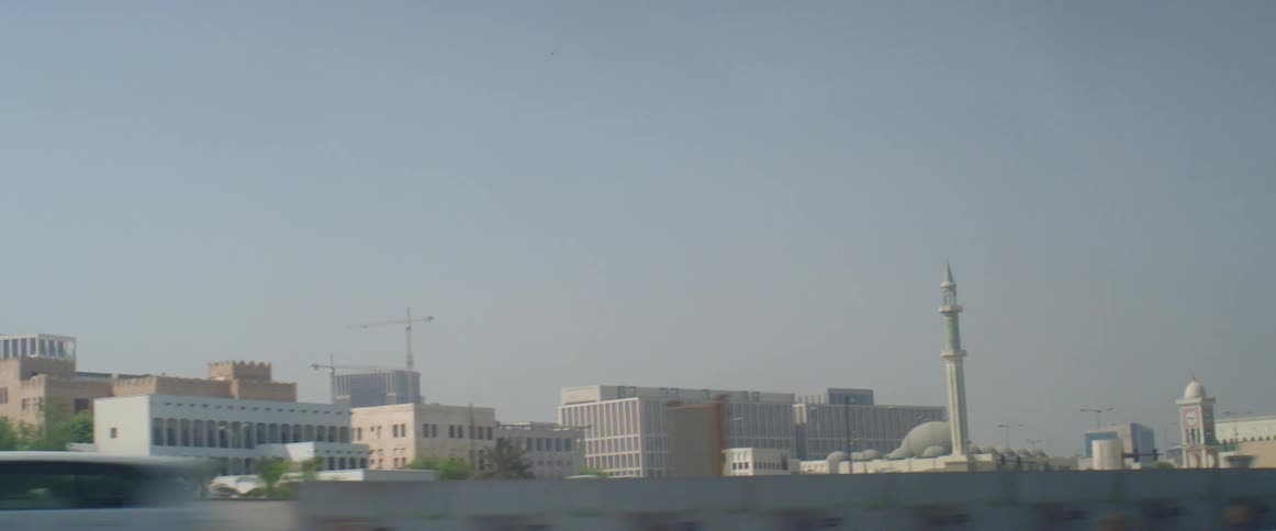Cars are driving on a highway through an urban city