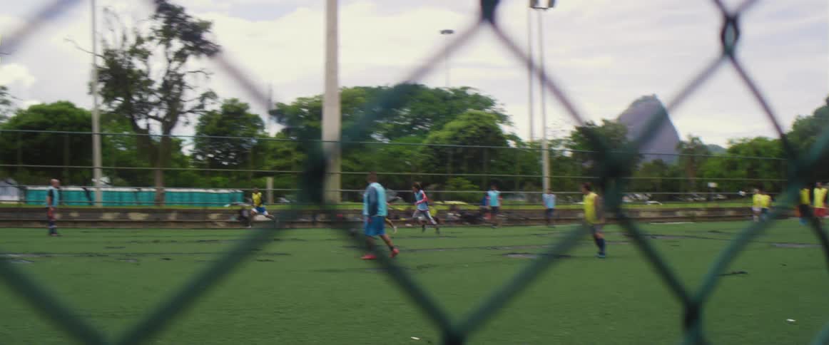 People are playing a game of soccer behind the fence