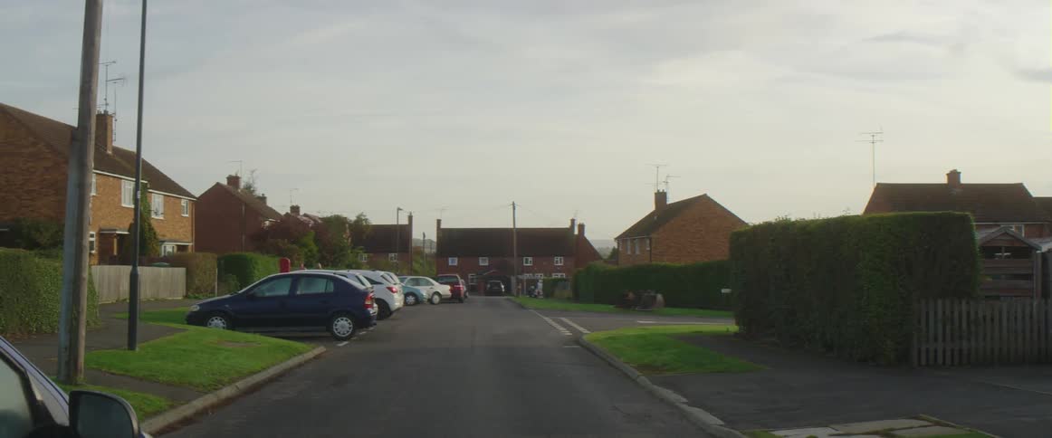 Many personal vehicles are parked in spots near residential buildings