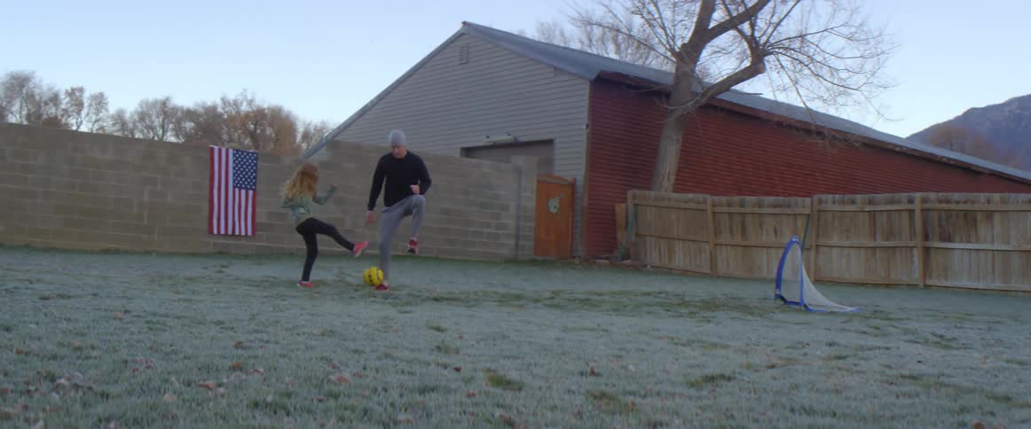 Father and daughter playing ball on the backyard at home in the morning