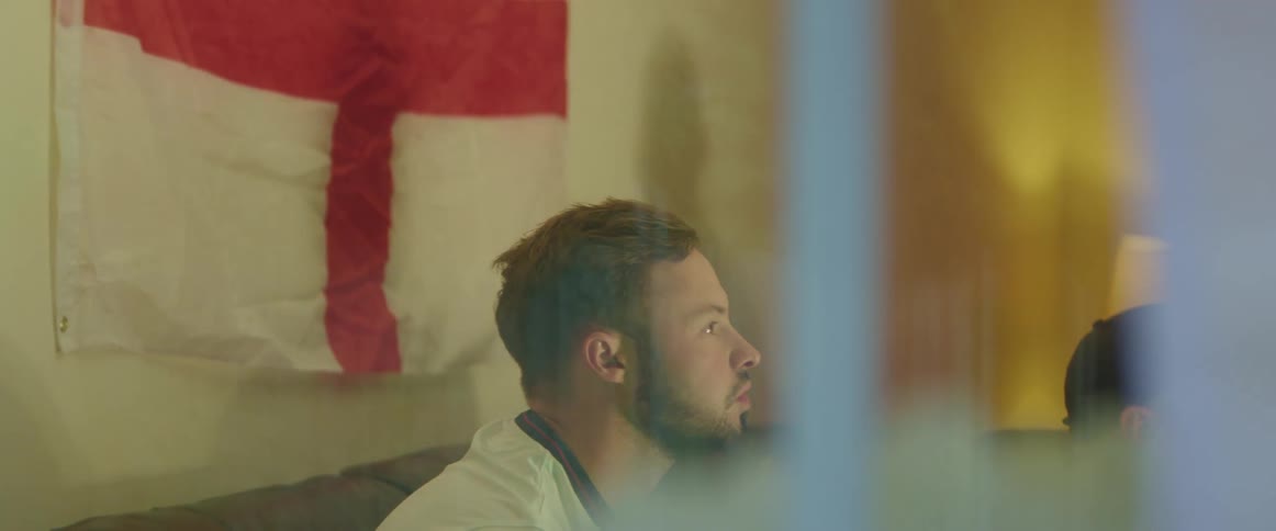 A man looks upset as he watches something