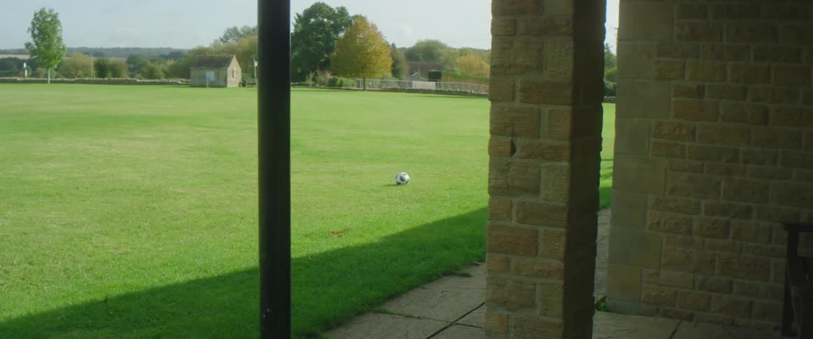 A soccer ball lying in a field on a sunny day