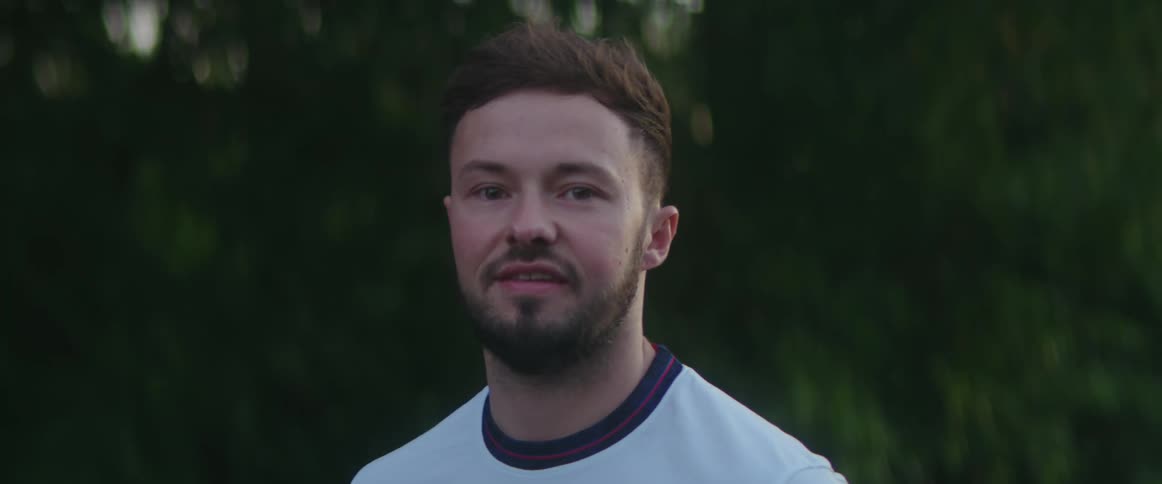 Man turns to look forward with a slight smile